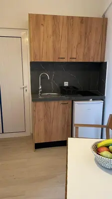 a kitchen with a sink and a bowl of fruit on a table at Gennadi Beach Apartments in Gennadi