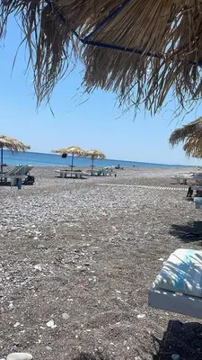 a beach with chairs and umbrellas and the ocean at Gennadi Beach Apartments in Gennadi