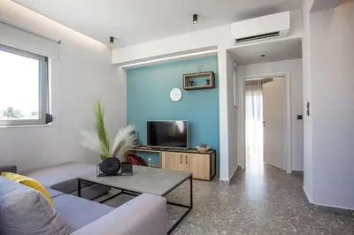 a living room with a couch and a tv at GM Apartments-Rhodes Luxury Living in Kalithies