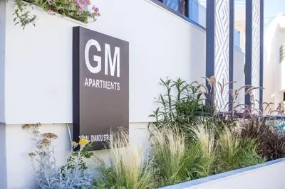 a sign on the side of a building with plants at GM Apartments-Rhodes Luxury Living in Kalithies