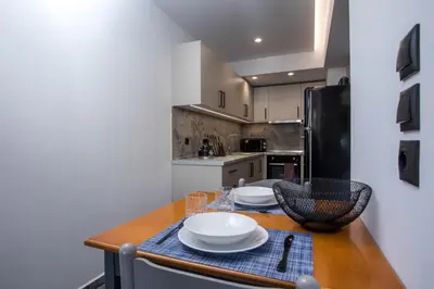 a kitchen with a wooden table with plates on it at GM Apartments-Rhodes Luxury Living in Kalithies