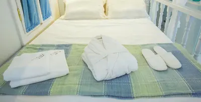 a bed with white towels and shoes on it at Efchi 1904 in Rhodes Town