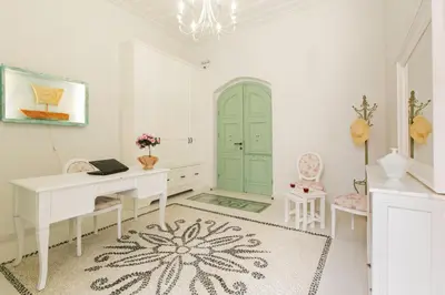 a white room with a desk and a green door at Efchi 1904 in Rhodes Town
