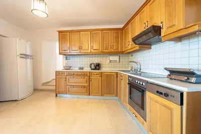 a kitchen with wooden cabinets and a white refrigerator at Arte Lindos Suites in Líndos
