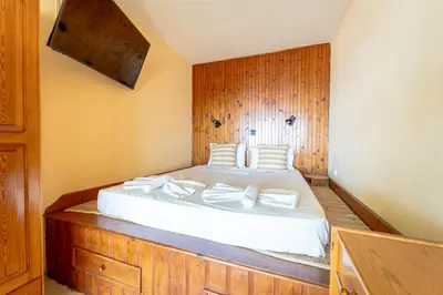 a bedroom with a large bed with a wooden wall at Arte Lindos Suites in Líndos