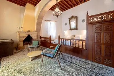 a room with two chairs and a bed and a fireplace at Arte Lindos Suites in Líndos