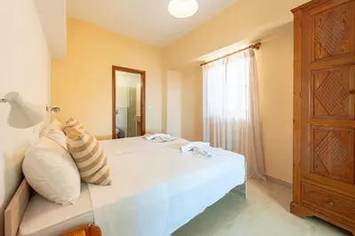 a bedroom with a white bed and a window at Arte Lindos Suites in Líndos