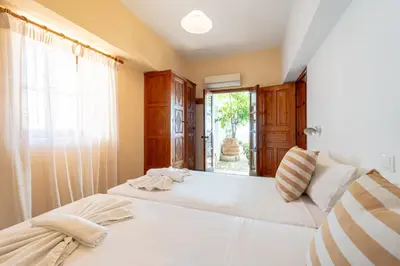 a bedroom with two beds and a window at Arte Lindos Suites in Líndos