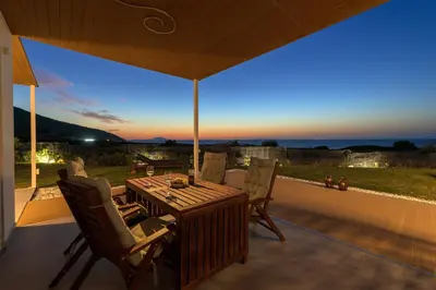 a patio with a table and chairs with a view at Niva Kamiros Apartments in Kamiros
