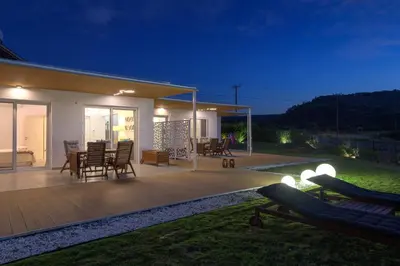 a house with a deck at night at Niva Kamiros Apartments in Kamiros