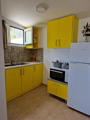 a kitchen with yellow cabinets and a white refrigerator at SOLYMAR PRIVE in Archangelos