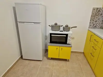 a kitchen with a refrigerator and two pots on a microwave at SOLYMAR PRIVE in Archangelos