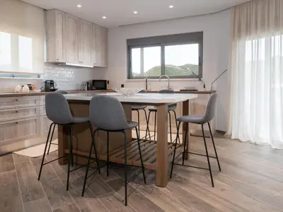 a kitchen with a island with chairs around it at Apartment Lazarous 3 in Apolakkiá