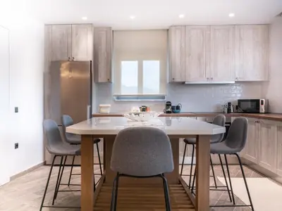 a kitchen with a table with chairs and a refrigerator at Apartment Lazarous 3 in Apolakkiá