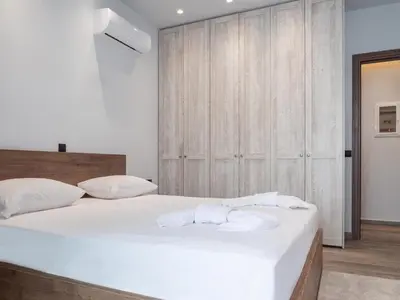 a bedroom with a large white bed with towels on it at Apartment Lazarous 3 in Apolakkiá