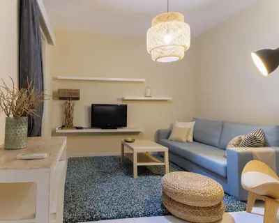 a living room with a blue couch and a tv at Apartment Lazarous 2 in Apolakkiá