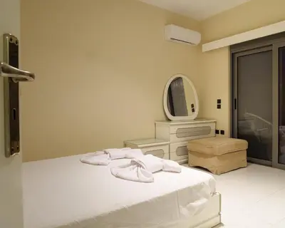 a bedroom with a white bed and a mirror at Apartment Lazarous 2 in Apolakkiá