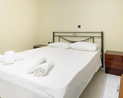 a bedroom with a white bed with towels on it at Apartment Lazarous 1 in Apolakkiá