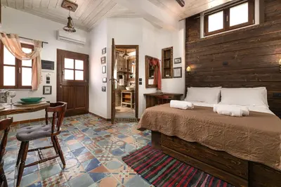 a bedroom with a bed and a table and chairs at Ey Sofias Suites in Rhodes Town