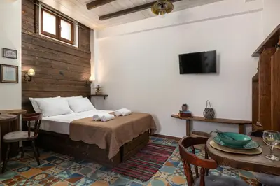 a bedroom with a bed and a table and a tv at Ey Sofias Suites in Rhodes Town