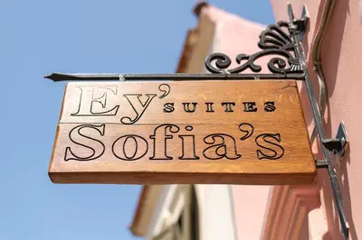 a sign on the side of a building that reads hy suites southern at Ey Sofias Suites in Rhodes Town