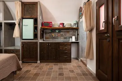 a kitchen with wooden cabinets and a tiled floor at Ey Sofias Suites in Rhodes Town