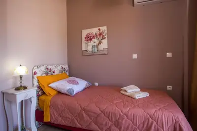 a bedroom with a bed and a table with a lamp at Kalypso Sea View Villa in Koskinou