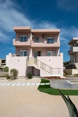 a large white house with stairs in front of it at Kalypso Sea View Villa in Koskinou