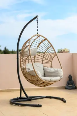 a hanging rattan swing chair on a floor at Kalypso Sea View Villa in Koskinou