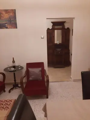 a living room with a red chair and a table at DIMITRA HOUSE in Rhodes Town
