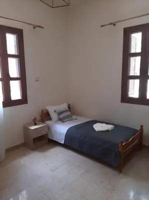 a bedroom with a bed and two windows at DIMITRA HOUSE in Rhodes Town