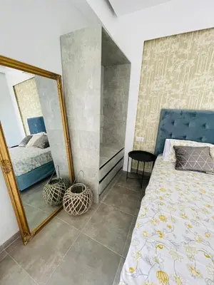 a bedroom with a mirror next to a bed at Vixen Apartment in Theologos