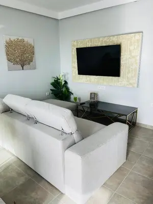 a white couch in a living room with a flat screen tv at Vixen Apartment in Theologos