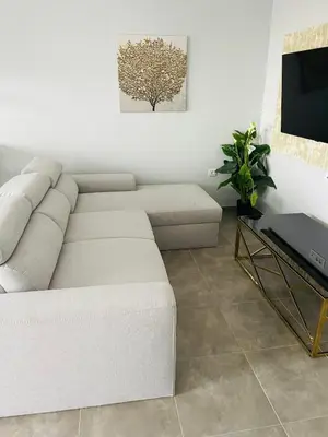 a living room with a white couch and a tv at Vixen Apartment in Theologos