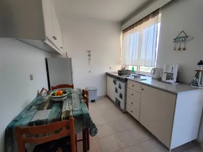 a kitchen with a table with a bowl of fruit on it at East View Appartment (Thanasis 1) in Kalavárda