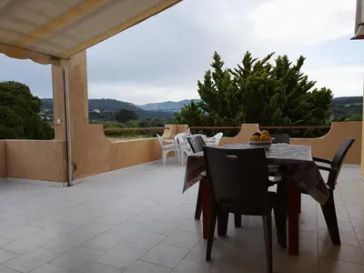 a patio with a table and chairs on a balcony at East View Appartment (Thanasis 1) in Kalavárda