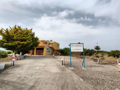 a building with a sign in front of it at Sunset View Appartment (Thanasis 3) in Kalavárda