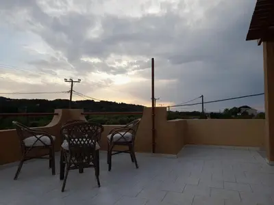 a patio with two chairs and a table on a balcony at Sunset View Appartment (Thanasis 3) in Kalavárda