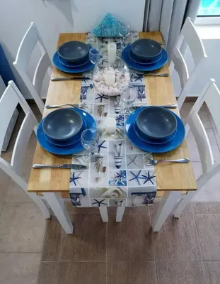 a wooden table with blue plates and glasses on it at Valantas Garden Suite in Lardos