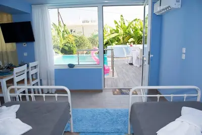 two beds in a room with a view of a pool at Valantas Garden Suite in Lardos
