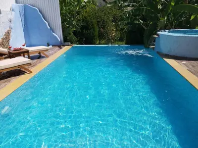 a large pool with blue water in a backyard at Valantas Garden Suite in Lardos