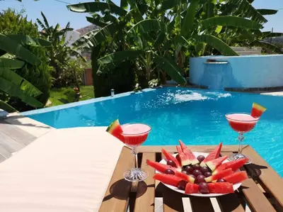 a table with two drinks and a plate of fruit at Valantas Garden Suite in Lardos