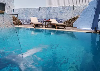 a swimming pool with two chairs and a table at Valantas Garden Suite in Lardos