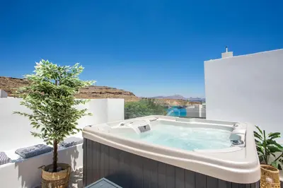 a hot tub on a balcony with a tree at Villa Euphrosyne in Líndos