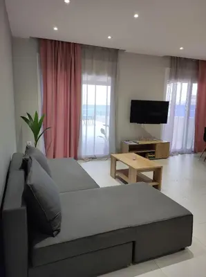 a living room with a couch and a flat screen tv at Nostalgia Apartment in Archangelos