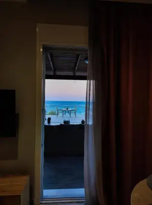 a room with a door open to a view of the ocean at Nostalgia Apartment in Archangelos