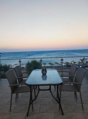 a table and chairs on a patio overlooking the ocean at Nostalgia Apartment in Archangelos