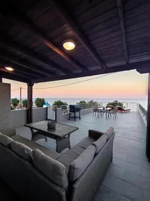 a patio with a couch and a table and the ocean at Nostalgia Apartment in Archangelos