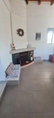 a room with a fireplace and a tile floor at Livadi house in Theologos