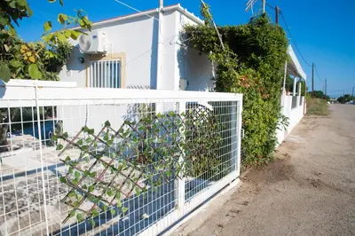 a fence in front of a white house at Livadi house in Theologos